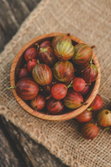 Ripe gooseberry in a wooden plate on nature