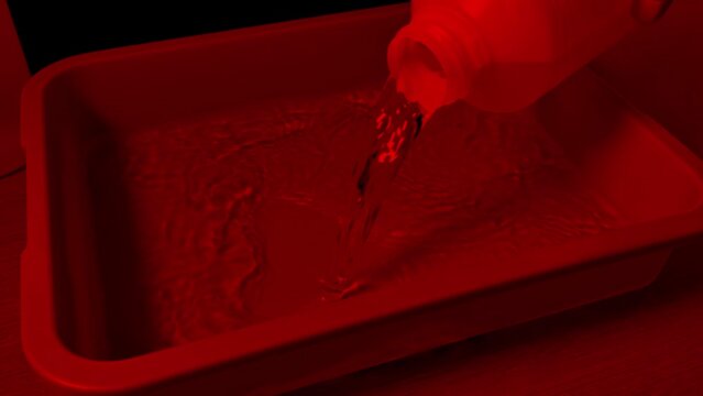 Photo Is Put Into Developer Liquid In Dark Room
