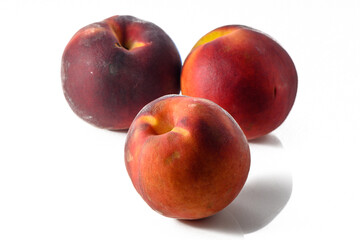 Three fresh peaches with leaves and drops of water