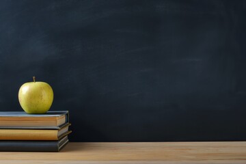 Obraz premium ed apple and books on the left side, with an empty blackboard background for copy space, solid color backdrop