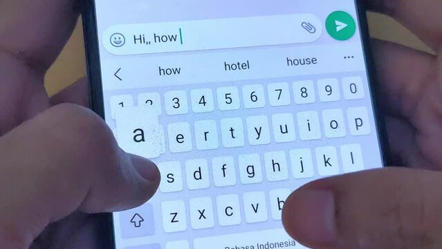 close up of a person typing Hi how are you. Hand hold mobile phone.
