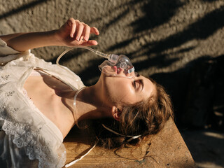 Woman in white dress wearing oxygen mask laying on ground