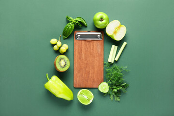 Composition with blank menu board and products on green background