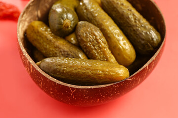 Bowl with delicious fermented cucumbers on red background, closeup