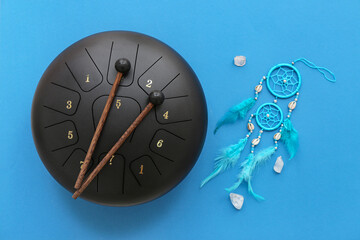 Glucophone with sticks, dream catcher and mineral stones on blue background