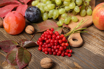 Rowan berries and fresh fruits on wooden background