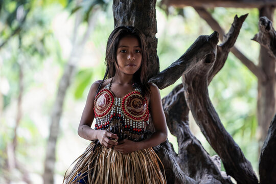 Wayuri indigenous girl in traditional dress gazes at the camera in Ecuadorian Amazon jungle