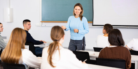 Female teacher teaching high school students in a school classroom
