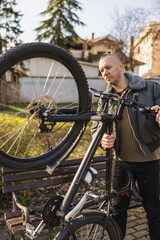 Man Inspects His His Mountain Bike