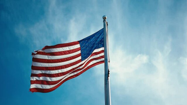 Waving American flag in the wind, symbolizing patriotism and freedom. Perfect for celebrating Independence Day on July 4th. High-quality footage for national pride and patriotic events.