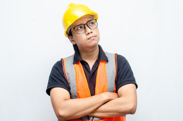 Title	
young asian man construction worker using yellow helmet and orange vest makes a thinking gesture. asian male worker in pensive expression while thinking looking for idea.