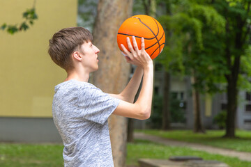 Young Man Holding Basketball Outdoors