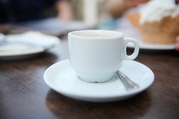 Close-up of coffee cup on wooden table in a cafe