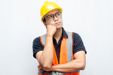 Title	
young asian man construction worker using yellow helmet and orange vest makes a thinking gesture. asian male worker in pensive expression while thinking looking for idea.