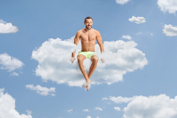 Man in swimwear sitting on a cloud