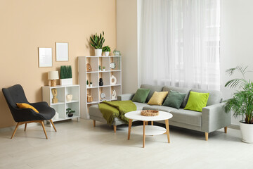 Stylish living room with comfortable sofa, coffee table, black armchair and curtains