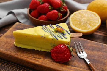 Board with tasty cheesecake pop and strawberry on table