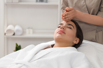 Beautiful young woman getting facial massage in salon, closeup