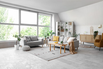 Interior of modern living room with sofas, table and big window