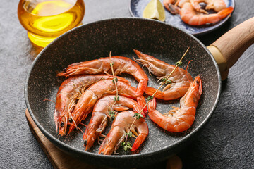 Frying pan with tasty boiled shrimps on dark background