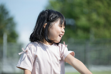 公園や芝生の上で楽しそうにはしゃいで踊る子供　アクティブな子どものイメージ