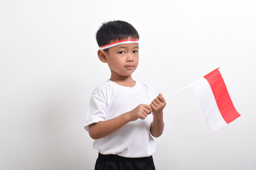 Cute little Asian boy holding Indonesia's flag to celebrate Indonesia Independence Day isolated on white background.