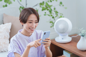 夏にスマホを使う女性