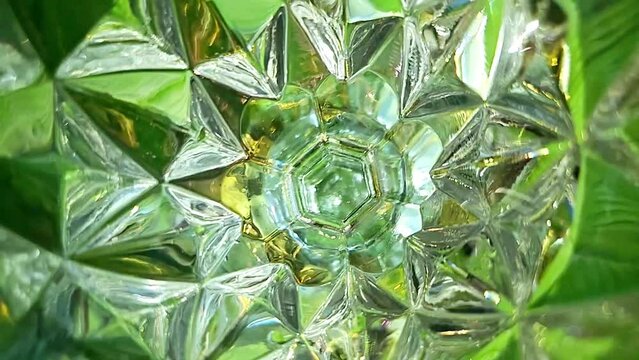 컬러풀한 무늬의 크리스탈잔 안에 물이 흔들리는 슬로우모션