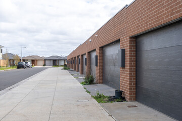 A row of garage doors of modern townhouses with gates closed in a residential neighborhood in an Australian suburb. Car Storages in a suburban community with concrete driveway.