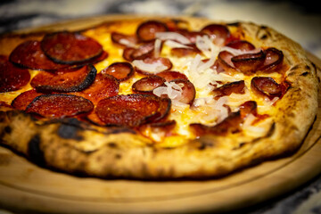 Calabrian sausage pizza served on a round board and set table