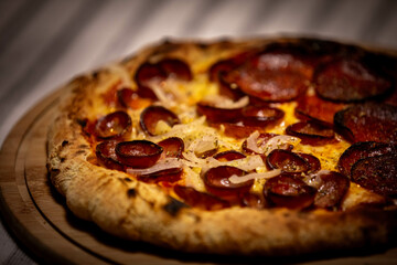Calabrian sausage pizza served on a round board and set table