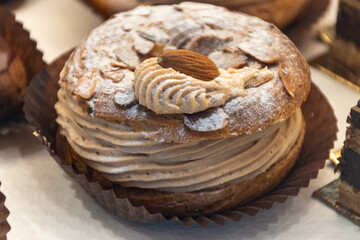 Freshly baked stuffed sweet Paris-Brest pastries in traditinal French bakery in small village in Provence