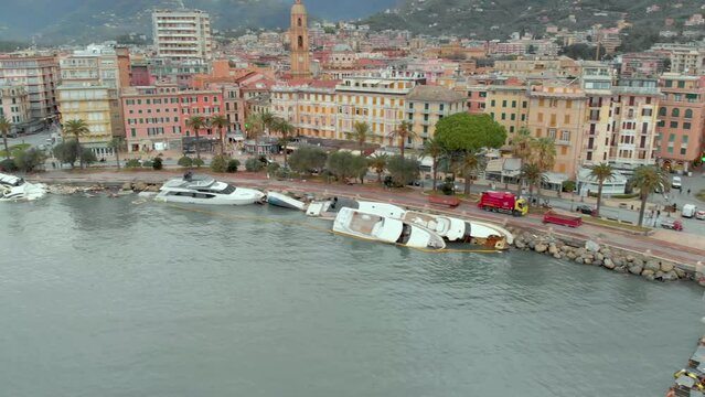 Aerial view of Carlo Riva Marina destroyed by powerful storm. Extreme disaster aftermath, sunken yachts and boats, piles of debris, catastrophic weather events damage. Rapallo, Italy.