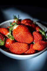 Plate with french organic red ripe sweet strawberries Fraises de Plougastel, harvested in France