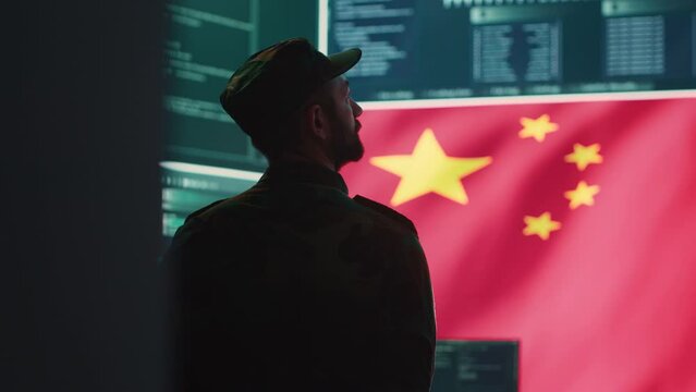 Chinese military personnel in a high tech government hacking room work on stealing state secrets from rival countries in hybrid war. Chinese army exploit advanced technology, inflict fear. Camera A.
