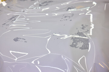 During the car wrapping process, hands are seen cutting window tint film for the job