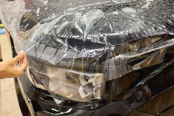 Workshop process of applying protective film to safeguard car headlights from scratches and damage