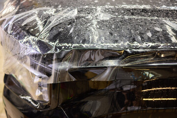 Workshop process of applying protective film to safeguard car headlights from scratches and damage