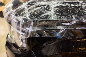 Workshop process of applying protective film to safeguard car headlights from scratches and damage
