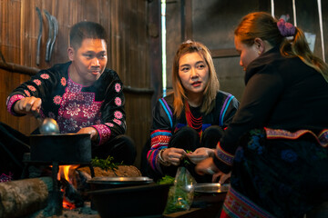 Asian family cooking and having dinner meal together at home. Hill tribe woman in traditional...
