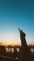Fototapeta premium Odaiba, Tokyo. March 13, 2024: Statue of Liberty in Tokyo with beautiful sunset. 