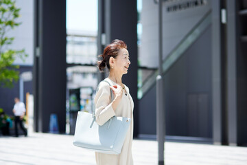 Fototapeta premium 春のオフィス街で働くシニア女性社長