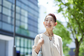 春のオフィス街で働くシニア女性社長