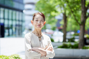 春のオフィス街で働くシニア女性社長