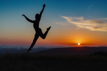 Silhouette of male ballet dancer jumping and doing a majestic dance move in nature, Behind him are heavenly clouds and the sun is setting.