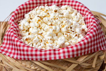 Straw hat with red and white checkered fabric and popcorn inside. Typical food for the São João June festival.