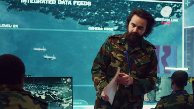 Commanding general of the navy division reviews warfare information within a mission case file, special operation reconnaissance to support field troops. Briefing his military squad. Camera A.