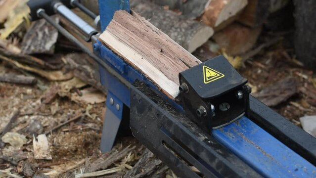 Hydraulic wood splitter splits wormwood. Preparation for the winter.