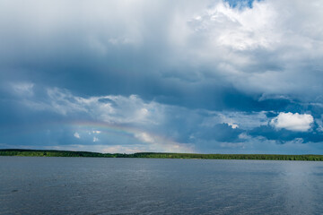 Rainbow over Blue lake with cloudy sky