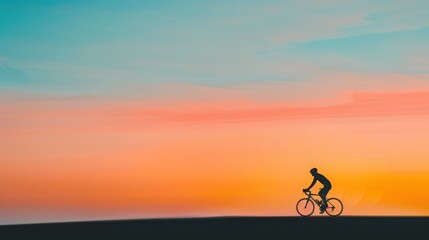 Obraz premium Silhouette of a cyclist riding a bike against a colorful sunrise or sunset sky, highlighting the beauty of early morning or evening exercise.